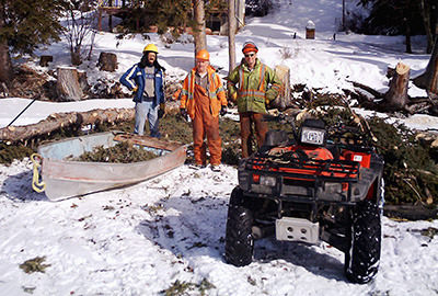 Ken Weadick, left, Jack Larson and Doug Kirkby with Larson's Woodchipping and Tree Removal worked for a week on properties along the Lac des Roches to remove dangerous trees. Jack's old boat makes a good branch hauler for firm and slushy snow. — image credit: Sharron Woloshyn