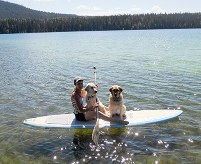 A beautiful day on Lac des Roches can only be enhanced by taking along your best friends. Marie Macchi has trained her dogs, London and Clark, to enjoy the water as much as she does on her paddle board. — image credit: Sharron Woloshyn