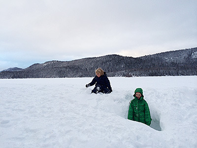 Cousins Noah Fowler, kneeling, and Cormac Munro spent their Christmas holidays playing in a snow fort they built next to Lac des Roches. The lake ice was covered with six inches of water and slush, which made it too wet for playing. — image credit: Kerry Braithwaite